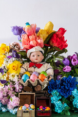 vertical sailor doll holding colored Easter eggs surrounded by spring flowers with white background