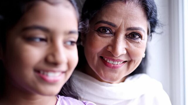 Indian grandmother and her young granddaughter smile. Scene captures generational bond and female empowerment. Perfect for awareness campaigns or family content.