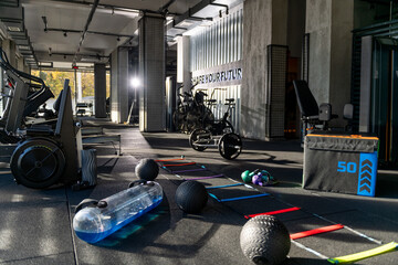 Gym Floor Setup with Agility Ladder Step Box Kettlebells Medicine Balls Water Bag Rowing Machine Treadmills