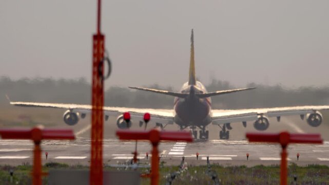 A huge wide-body four-engine airliner on the runway, rear view. Concept aviation, flight, tourism, cargo transportation, travel