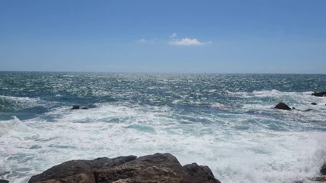 Turquoise Waves and White Sea Foam Crashing on Coastal Rocks