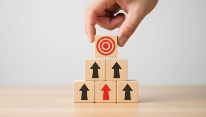 Hand Placing Wooden Block with Target Icon on Top of Pyramid