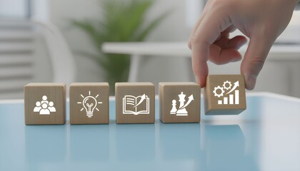 Hand selecting wooden block with graph icon on office desk with icons representing business concepts