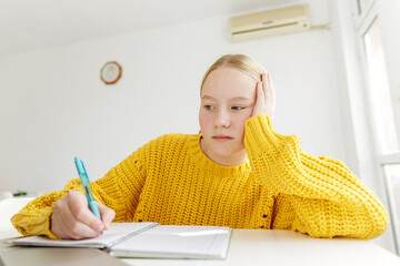 Teenage girl feeling tired while doing homework at home, student struggling with concentration, learning fatigue, lack of motivation, education stress, modern childhood