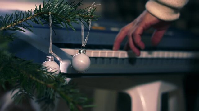 Christmas tree with woman playing Christmas carols on piano organ in background