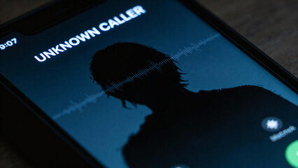 A phone screen shows an unknown caller with a dark silhouette. Sound waves are visible, indicating an incoming call. The background is dimly lit