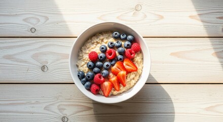 bowl of oatmeal with fresh berries on sunlit wooden table for healthy breakfast