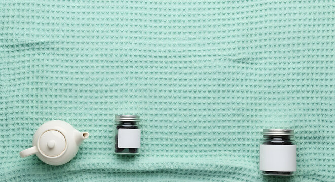 White ceramic teapot and two blank label jars on mint waffle fab