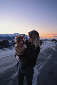 Mujer cagando a su hija en Atlantic Ocean road. Mother holding her daughter on Atlantic Ocean Road in winter, Norway. Mother and daughter exploring Atlantic Ocean Road in Norway during winter