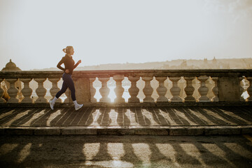 Woman runs along the seaside walkway in Malta during sunset