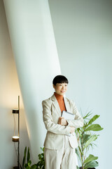 Professional woman in a light suit stands confidently in a modern office space