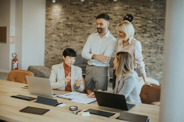 Business team collaborating in office with technology and discussion at a meeting table