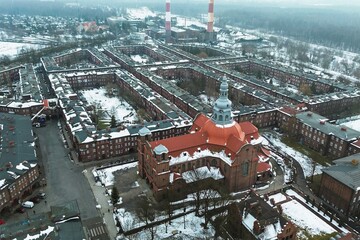 Naklejka premium Traditional European housing estate with church in snow