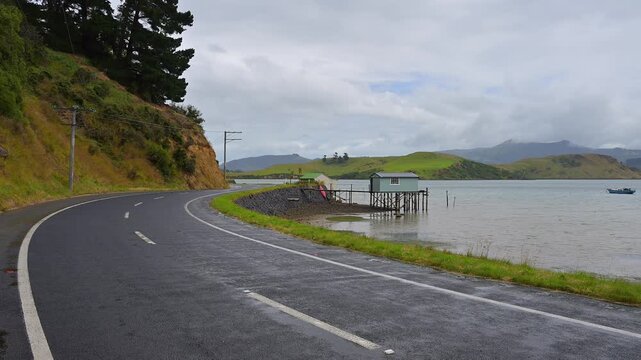 K&uuml;stenstra&szlig;e entlang des Wassers mit B&auml;umen und Felsen im Hintergrund, Broad Bay, Dunedin, Otago, S&uuml;dinsel, Neuseeland, Ozeanien 