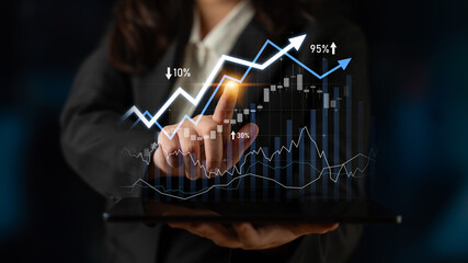 A business professional focuses on financial growth charts displayed on a digital tablet, highlighting rising statistics and trends that signify success. Scalp