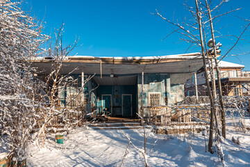 Old abandoned wooden house, boat station on a winter day