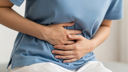 Person Suffering from Stomach Pain and Abdominal Cramps Holding Belly Closeup