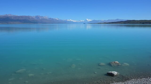 Klarer, ruhiger See vor einer fernen Bergkette unter blauem Himmel, Lake Pukaki Viewpoint, Pukaki, Canterbury, S&uuml;dinsel, Neuseeland, Ozeanien