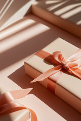 Red gift boxes wrapped with soft pale pink ribbons arranged on a pastel pink background. Minimal and elegant festive composition