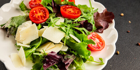 Parmesan cheese vegetable salad tomato, arugula, green leaf lettuce healthy food main course ingredient appetizer fresh tasty gourmet food background on the table rustic food top view copy space  