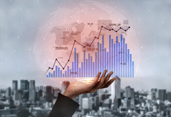 A close-up of a hand holding digital graphs representing financial data and trends, set against a blurred urban background, illustrating business growth and analytics. Scalp