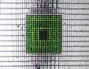 Explore the digital frontier with this macro shot of a green pixel grid on a textured surface. Perfect for tech, data security, and abstract concepts symbolizing precision and focus.