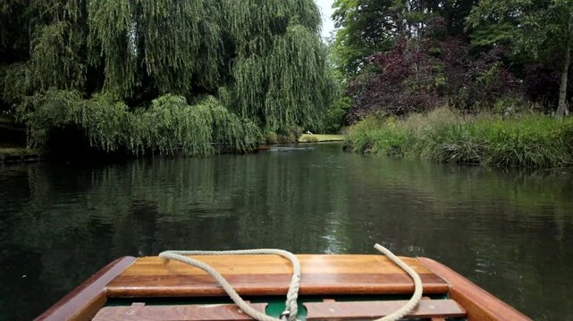 Small Wooden Boat Gliding On Calm Tree Lined River