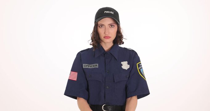 Police woman in dark uniform wears handcuffs on own wrists. Arrested officer raises chained hands representing punishment for corruption slow motion