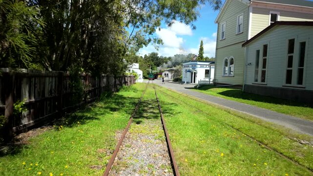 Walking Along Grass Covered Railway Tracks Past Old Buildings
