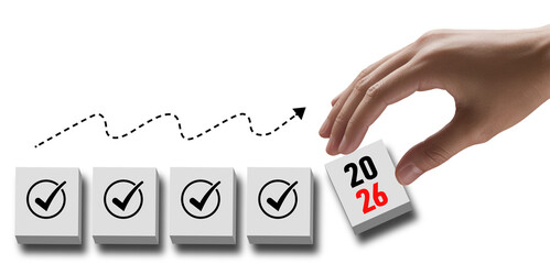 A hand places a block with the year 2026 next to completed task blocks