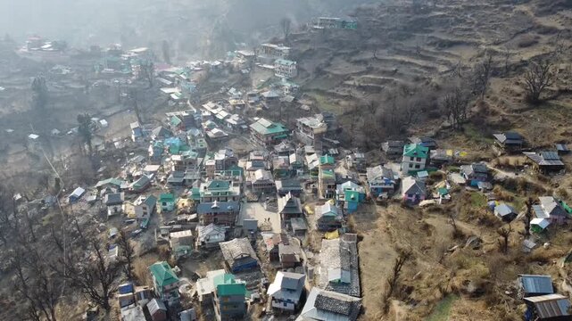 Aerial view of Tosh village nestled in Parvati Valley also cover Panoramic view of Tosh village at sunset, scenic mountains and pine forests in Kullu district, India.
