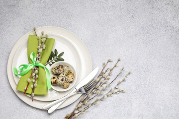 Festive table setting with Easter eggs and willow branches on light background, flat lay. Space for...