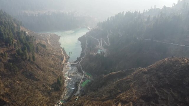 Aerial view of Tosh village nestled in Parvati Valley also cover Panoramic view of Tosh village at sunset, scenic mountains and pine forests in Kullu district, India.