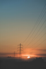 Foggy Sunrise And Electricity Pylons