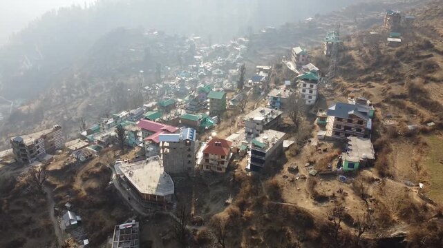Aerial view of Tosh village nestled in Parvati Valley also cover Panoramic view of Tosh village at sunset, scenic mountains and pine forests in Kullu district, India.