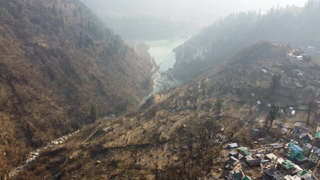 Aerial view of Tosh village nestled in Parvati Valley also cover Panoramic view of Tosh village at sunset, scenic mountains and pine forests in Kullu district, India.