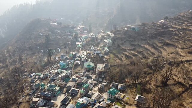 Aerial view of Tosh village nestled in Parvati Valley also cover Panoramic view of Tosh village at sunset, scenic mountains and pine forests in Kullu district, India.