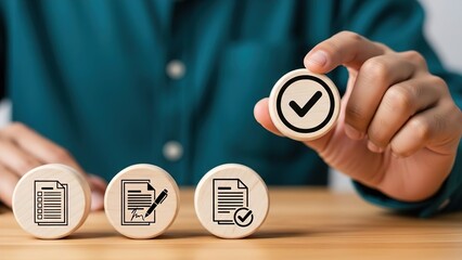 Person holding a wooden block with a checkmark icon, symbolizing approval or completion of a task or document process on a wooden table.