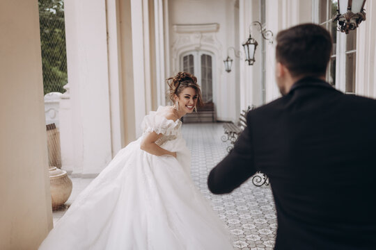Bride smiles during wedding photo session in historic building courtyard