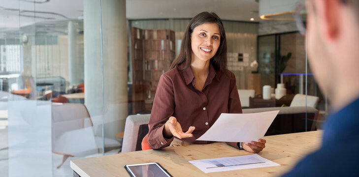 Young bank worker woman explaining working service process to client. Female hr reading cv talking with employee, business partner, working in office. People discussing project. Web banner, copy space