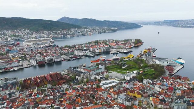 star shaped green fortress stands historic harbor point colorful houses stationary industrial vessels surround deep blue water norway bergen city center port star-shaped architecture 