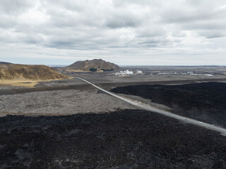 Fresh lava field on the Reykjanes Peninsula in Iceland formed after a recent volcanic eruption in spring 2024. The dark volcanic terrain and hardened lava flows create a dramatic landscape near the Bl
