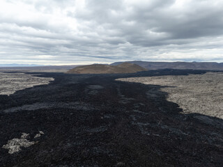 Fresh lava field on the Reykjanes Peninsula in Iceland formed after a recent volcanic eruption in spring 2024. The dark volcanic terrain and hardened lava flows create a dramatic landscape near the Bl