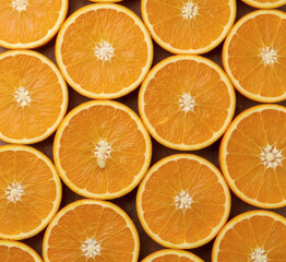 Vibrant Orange Slices Pattern. Close-up of fresh orange slices arranged in perfect grid, juicy pulp and white pith glowing on dark wooden background.