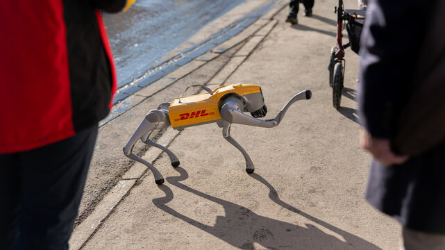 Davos, switzerland, january 20th 2026 robotic delivery dog with logistics brand logo walking outdoors