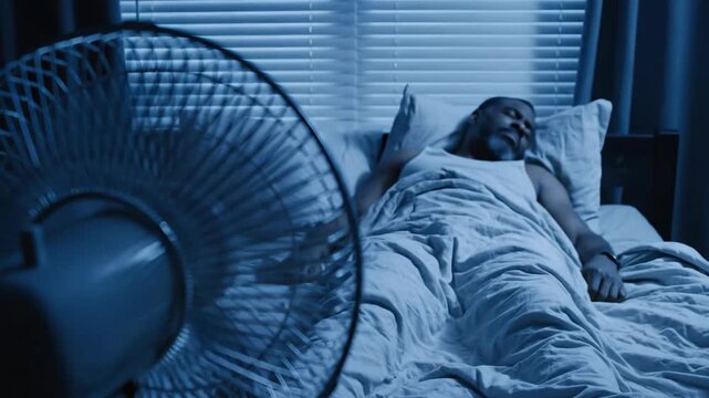 Warm night air brings restless moments in a cozy bedroom. A fan spins aimlessly as a person struggles to embrace peaceful sleep, lost in thoughts and dreams.