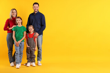 Portrait of happy family on orange background, space for text