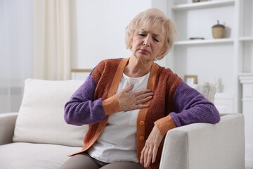 Fototapeta premium Heart attack. Senior woman suffering from pain in chest indoors