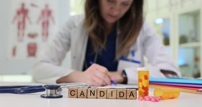 Wooden cubes arranged neatly emphasize identified fungal condition. Woman doctor writes prescription for patient concentrating on dosage details