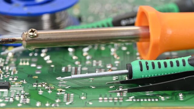 Video of an electrical circuit board with a soldering iron, solder,